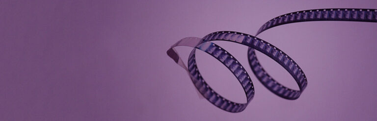 Reel of film on purple background