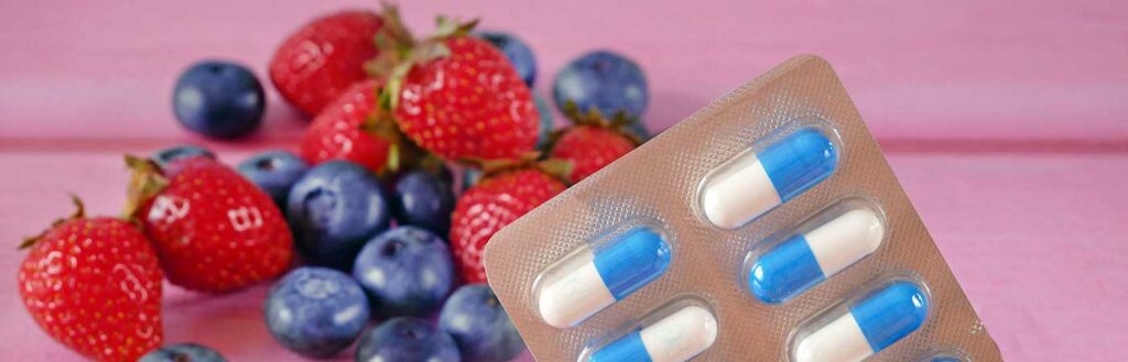 Blister pack of capsules with strawberries and blueberries.
